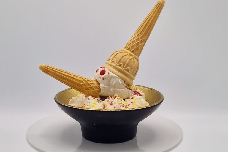 Pinocchio Eis Eisdessert in einer Schale mit zwei Waffelhörnern und bunten Streuseln.