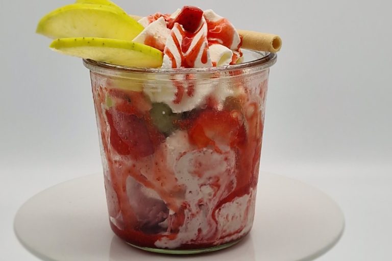 Früchtebecher Früchtebecher mit diversen Früchten, Soße, Sahne, Limettenscheiben und einem Keks.