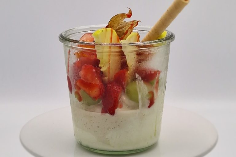 Joghurtbecher im Glas Ein Glas mit Joghurt, frischen Erdbeeren, Vanilleeis und einem Waffelstäbchen.