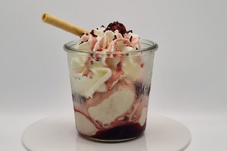 Amarena Becher Ein Becher mit Eis, Sahne, Kirschen und einer Waffelrolle obendrauf.